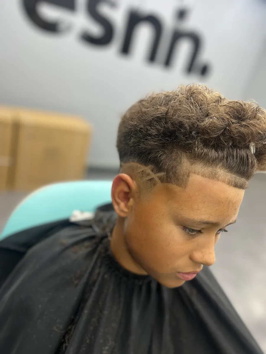 Lockiges Deckhaar mit Fade und Muster an der Seite