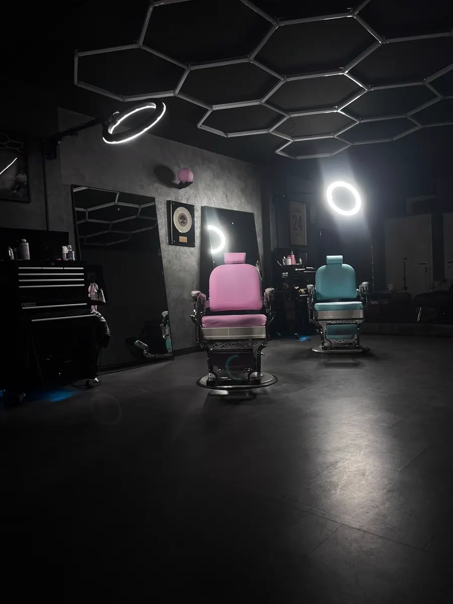 Pinker und türkiser Stuhl nebeneinander, beleuchtet von Ringlichtern